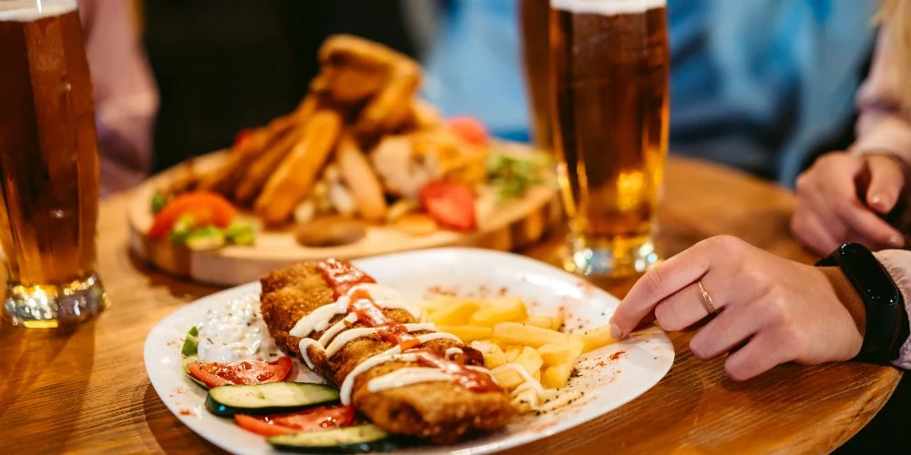 観戦しながらビールで乾杯するお客さんとフードプレート