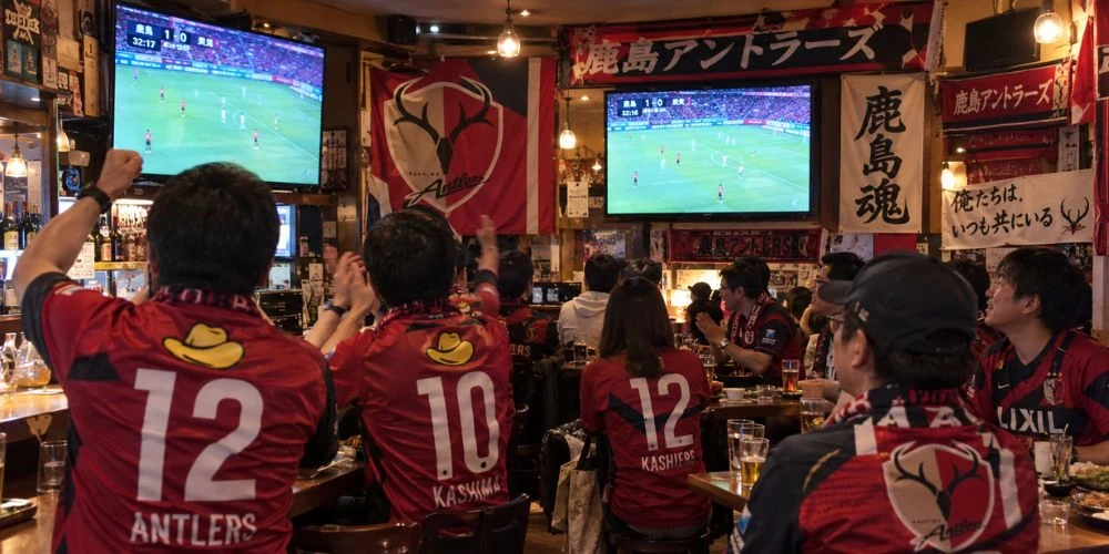 居酒屋のテレビで試合を観戦するファン